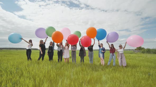 Girls Friends Stand on the Field with Large and Colorful Balloons