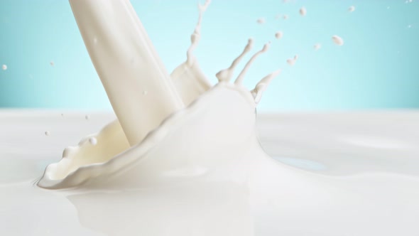 Super Slow Motion Shot of Pouring and Splashing Fresh Milk on Blue Background at 1000 Fps