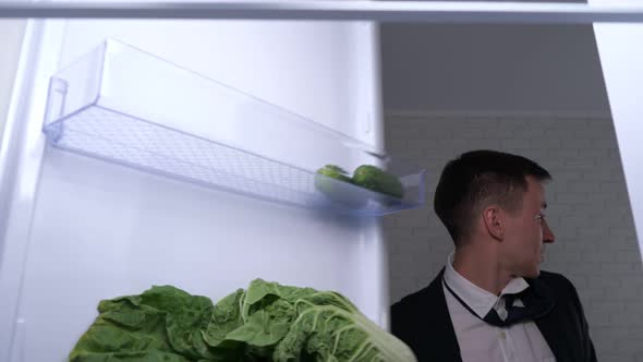 Joyful Guy in Suit Rubs Hands and Takes Beer From Fridge