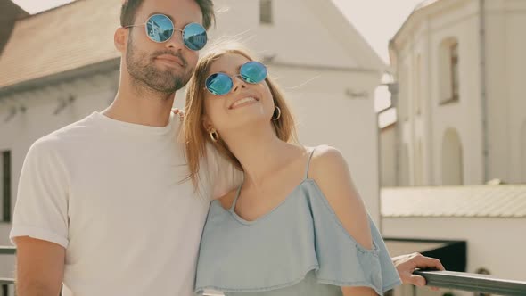 Portrait of smiling beautiful female and her handsome boyfriend posing outdoors