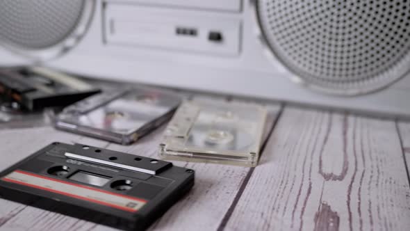 Female Hands Throwing a Lots Old Audio Cassettes on Table