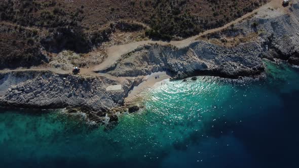Bird eye view drone shot of Albanian coast in the Mediterranean sea - drone is descending, facing a