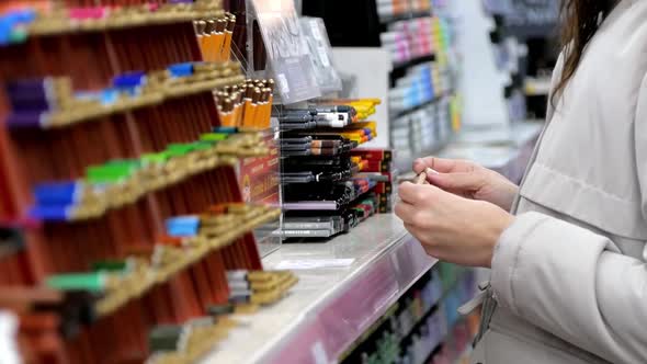 A Young Girl Artist Chooses Pencil in an Art Store