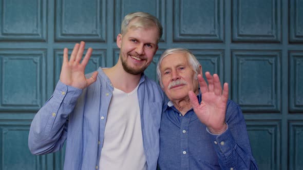 Happy Different Male Generations Family of Senior Father and Adult Son or Grandson Waving Hi Hello