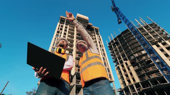 Male Engineers in Uniform Work with Laptop on a Site. alt