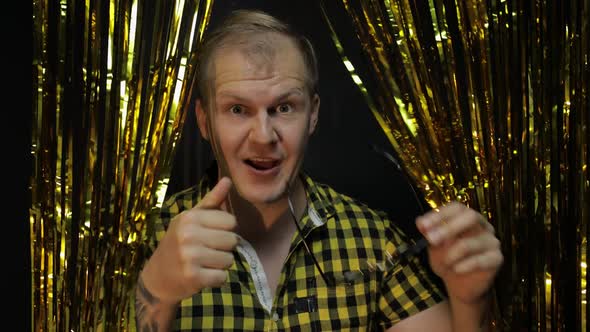 Portrait of Caucasian Man Posing on Black Background. Gold Shining Foil Strips. Party, Music, Disco