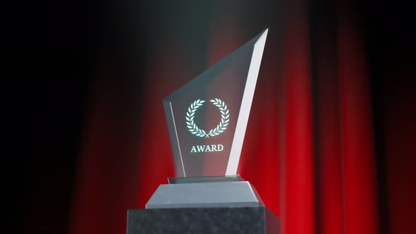 Crystal glass award on a stage with a red curtain in the background. 4KHD