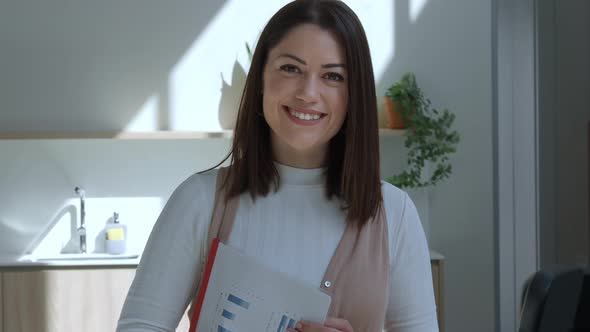 Smiling Spanish Woman Looking at Camera Seriously in an Office