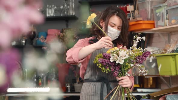 Female Adding New Flower To Bouquet. Asian Woman Florist Holding a Half Made Arrangement