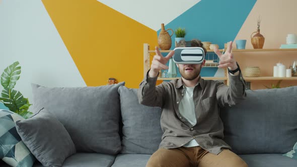 Bearded Guy Playing Game Wearing Virtual Reality Glasses Moving Arms at Home