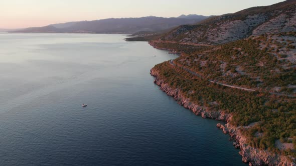 Aerial View Landscape Rocky Coast of Croatia with Curvy Mountain Road at Sunset