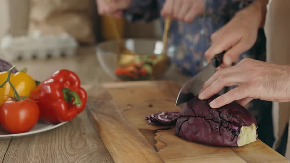 Close Up View of the Two Male Hands Cooking Together Cutting the Cabbage and Other Doing the Salad