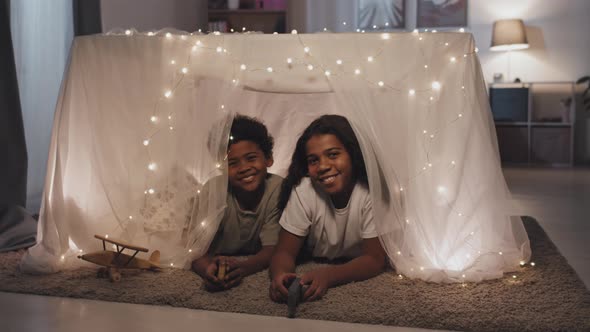 Siblings Posing in Blanket Fort