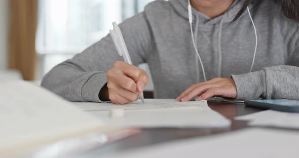 Woman write on the note paper ,study with cellphone