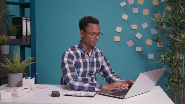 Financial Analyst Giving Thumbs Up for Work in Front of Laptop