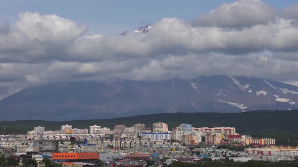 Summer Townscape on Background of Volcano Cloud Floating Across Sky on Sunny Day