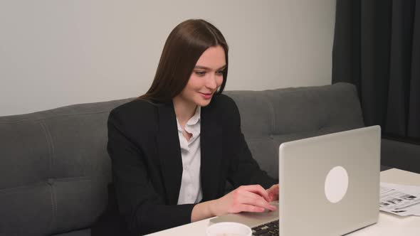 Smiling Woman Using Laptop at Home or Office