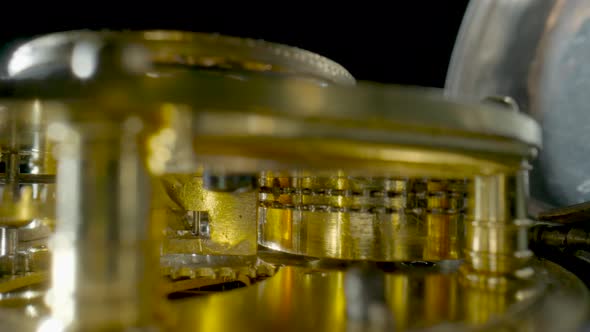 Inside View of a Moving Clockwork of Golden Mechanical Clock on Black Isolated Studio Background