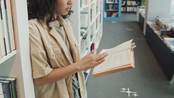 Asian Student Reading Paper Book in Library