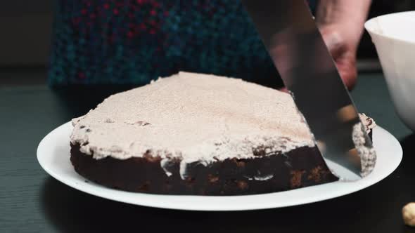 Female pastry chef pours cream on sponge biscuit cake