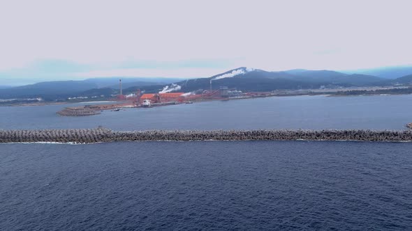 Aerial drone shot over large ship unloading raw materials in the port of the alumio factory in San C