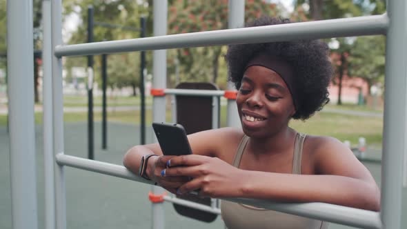 Black Woman Using Smartphone at Outdoor Training