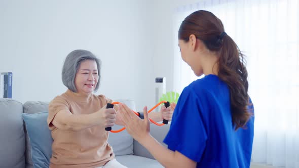 Asian Disabled old woman doing physiotherapist with support from nurse.