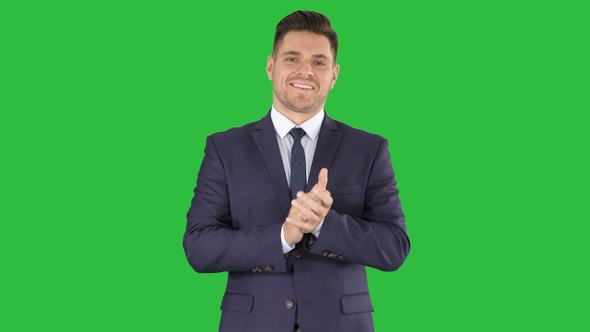 Smiling businessman clapping hands on a Green Screen, Chroma Key.