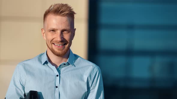 Portrait of Adorable Young Laughing Man Wearing Shirt Posing Surrounded By Sunlight