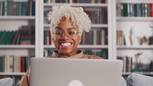 Young African American Woman with Laptop on Lap Overjoyed Winning Competition