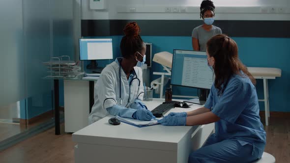 Doctor and Nurse Working with Prescription Document for Patient