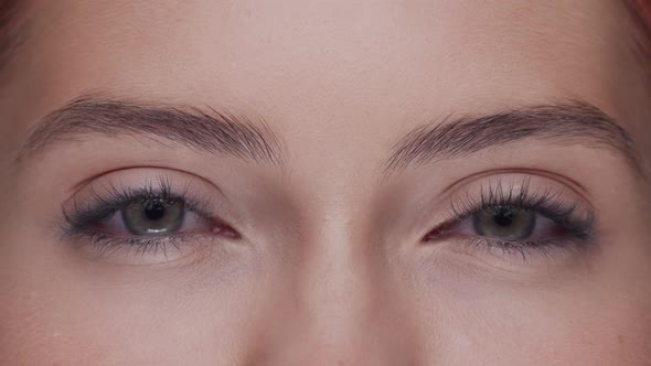 Close-up portrait of young, beautiful and natural woman opening her eyes.