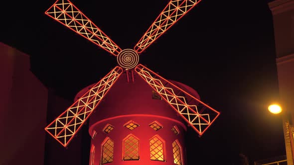 Moulin Rouge night view in Paris Spinning red mill