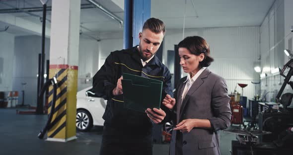 In a Garage Attractive Man Mechanic and a Woman