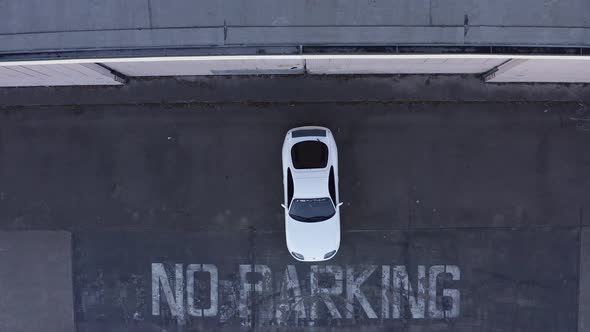 Aerial: white Toyota Supra no parking, descending drone.