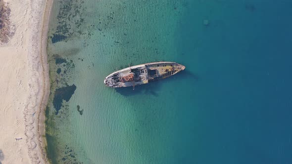 A Wrecked Wooden Ship Lies on the Seashore Covered with Rust