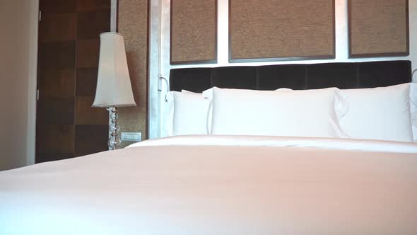 Kingsize Bed in Hotel Bedroom, White Sheets, Pillows and Lamps, Panorama