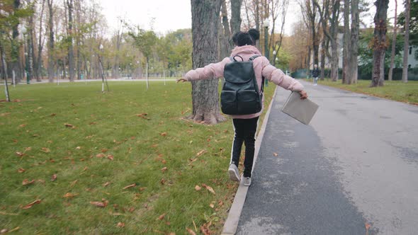 Back View Schoolgirl Walk on Curb Little Girl with Black Backpack Keep Balance Child Going to School