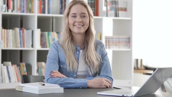 Smiling Young Woman Looking at Camera in Office