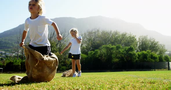 Children playing a sack race in park