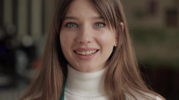 Pretty Caucasian Woman Smiling on Camera at Cafe