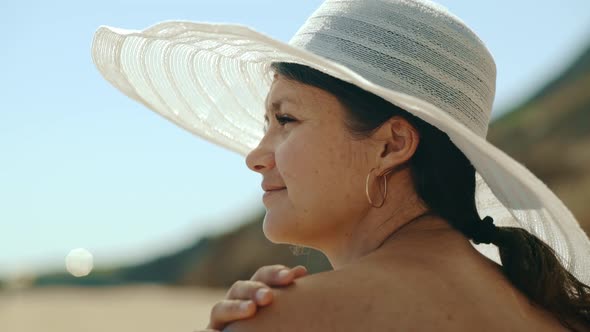 Portrait of a Young Girl in a Hat Who is Relaxing on the Sunny Coast