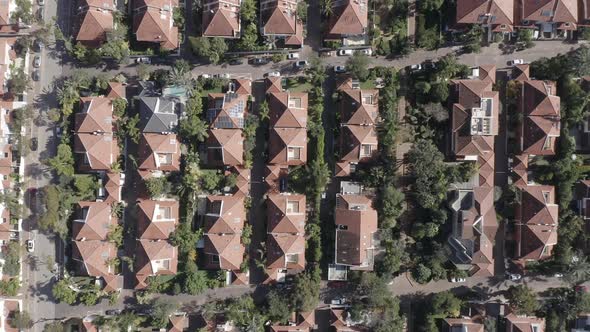 Classic Suburban houses with red rooftops and green trees.