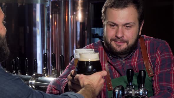 Friendly Bartender Clinking Glasses with Customer, Drinking Beer