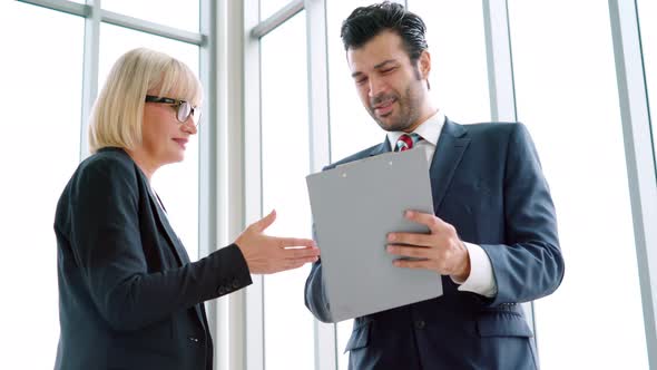 Two Business People Talk Project Strategy at Office