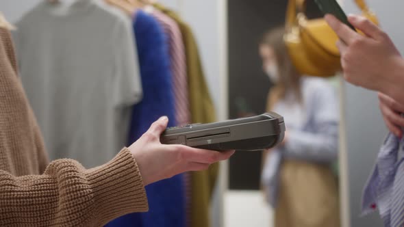 Closeup of Woman Making Payment Using Nfc in Showroom Fashion Clothes Store for Brand New Shirt and