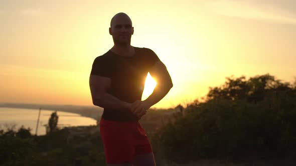 Footage of Muscular Bald Bodybuilder Man Wearing Black Tshirt Posing Smiling on Camera Showing