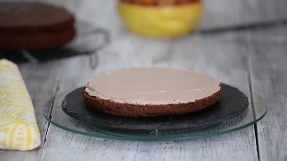 A confectioner puts caramelized bananas on a cake. Process of cooking chocolate sponge cake.	