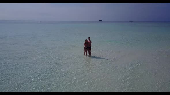 Man and woman sunbathe on perfect lagoon beach time by aqua blue lagoon and white sand background of