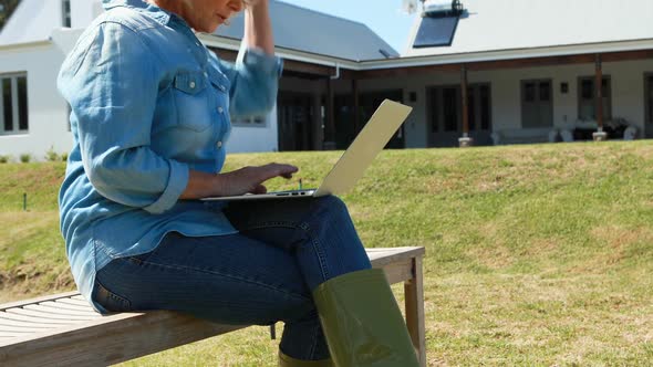 Senior woman using laptop in park